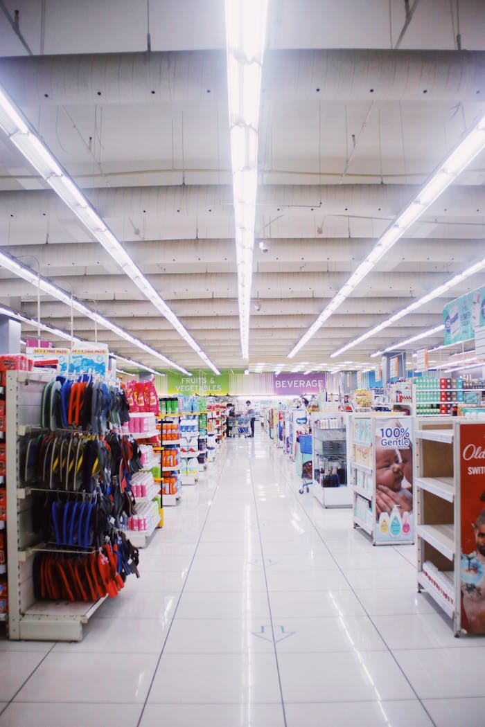 Interior of light spacious hallway among shelves with assorted products in contemporary supermarket